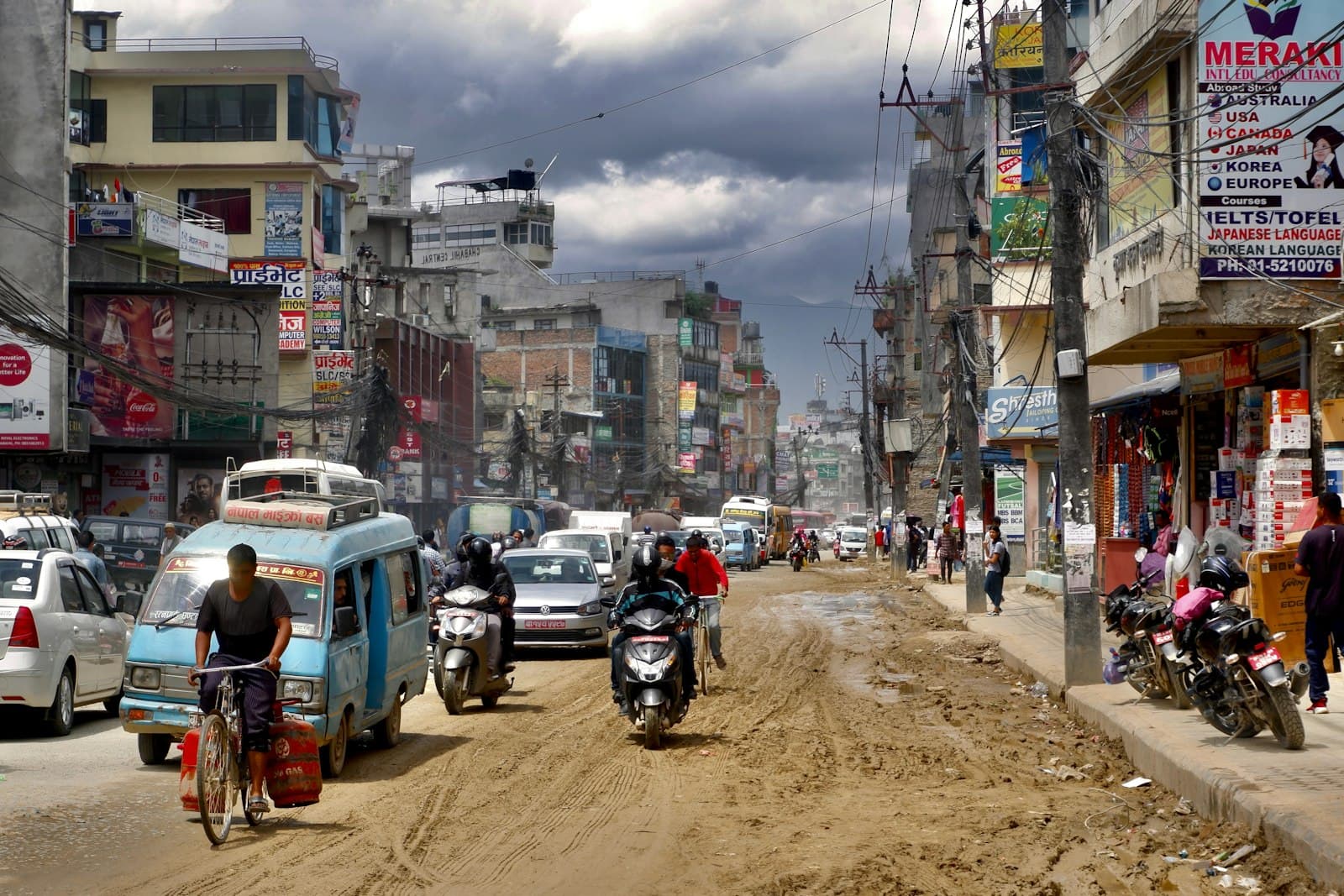 A busy street in Nepal with cars, bikes and scooters