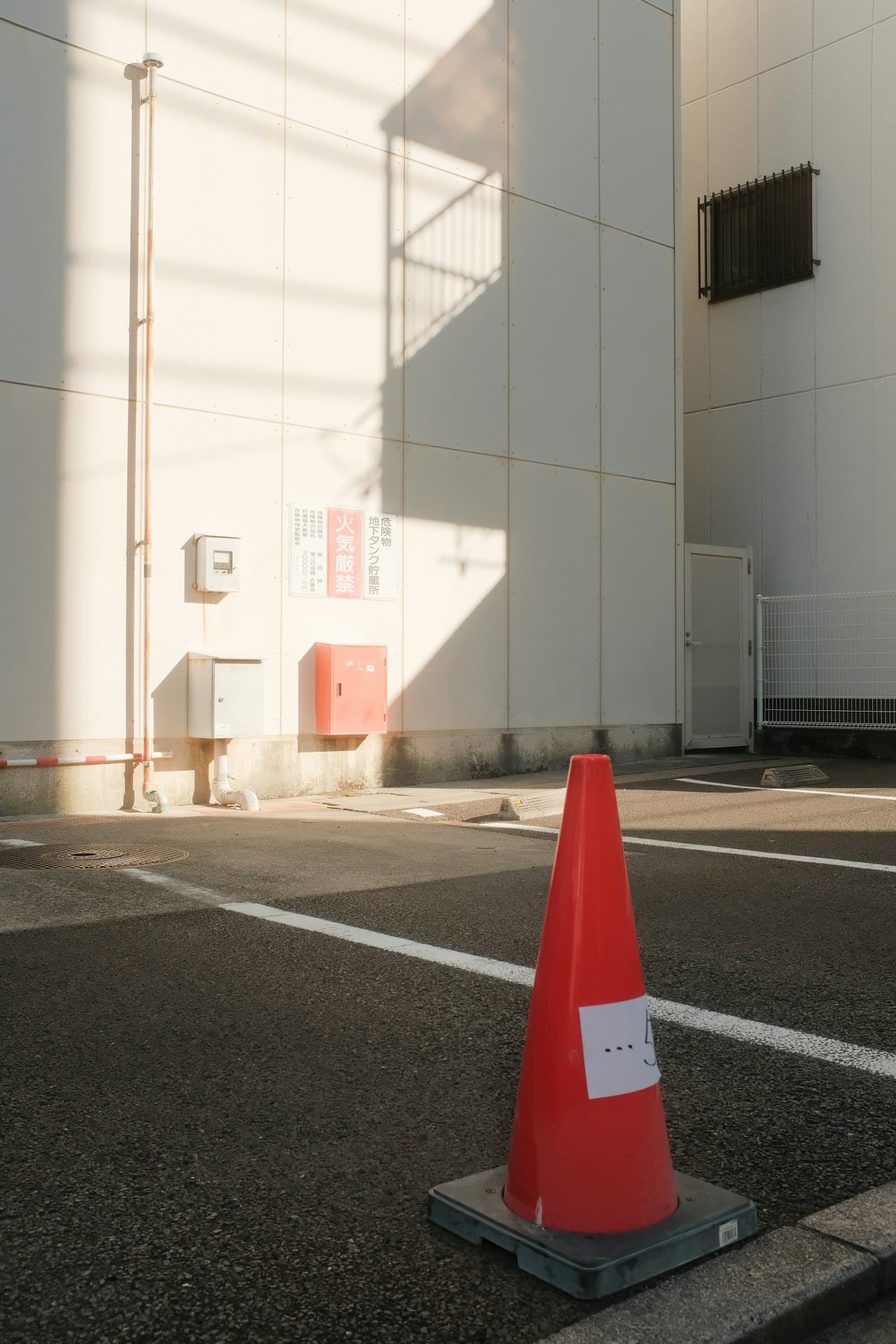 A traffic cone in the middle of a parking lot