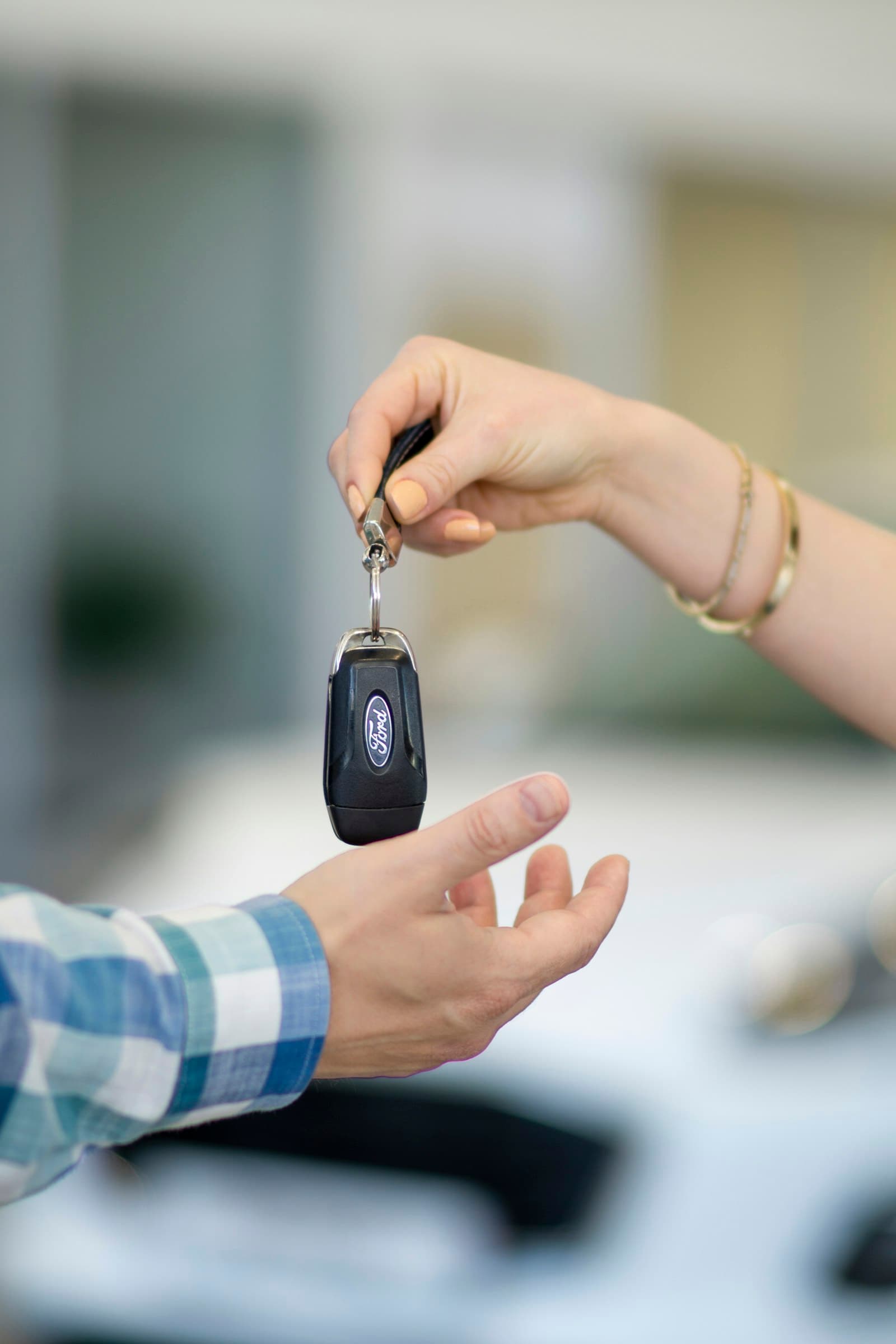 A car key being handed to a customer