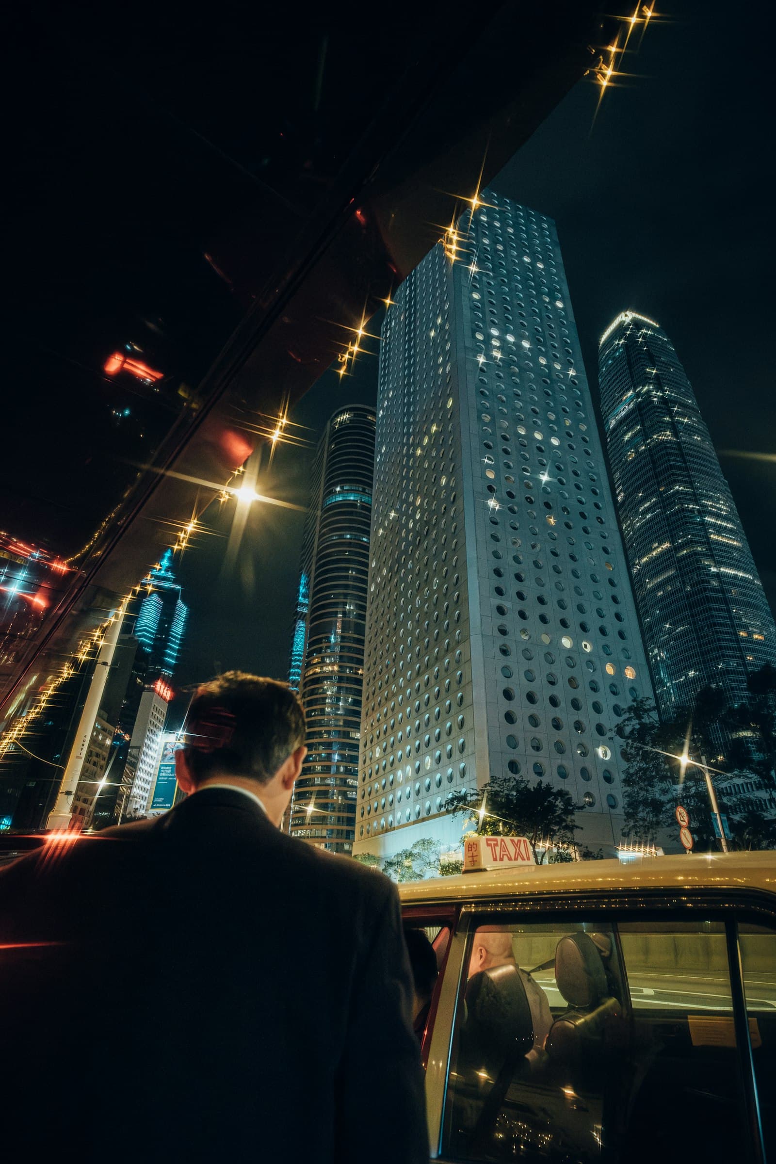 A passenger getting into a car at night