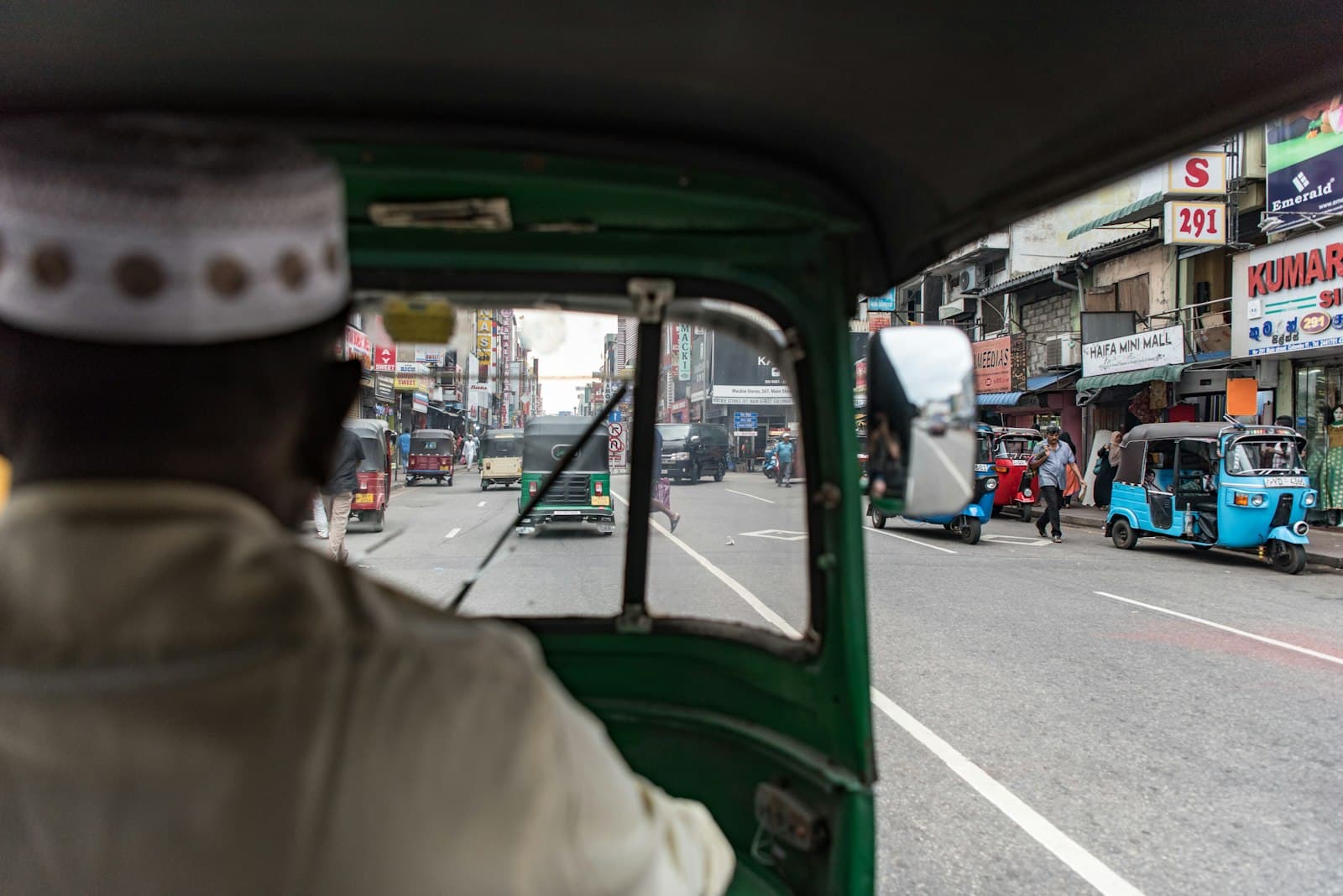 A passenger's view from an auto-rickshaw on a busy street