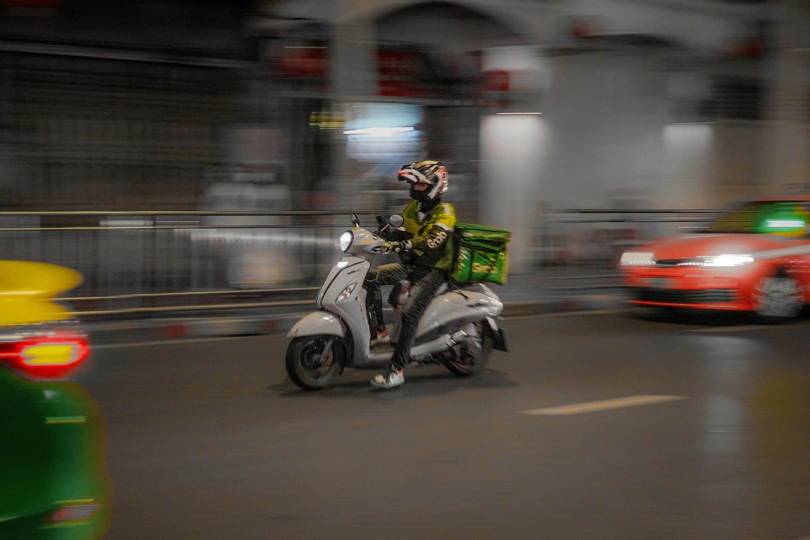 A scooter rider moving through city traffic